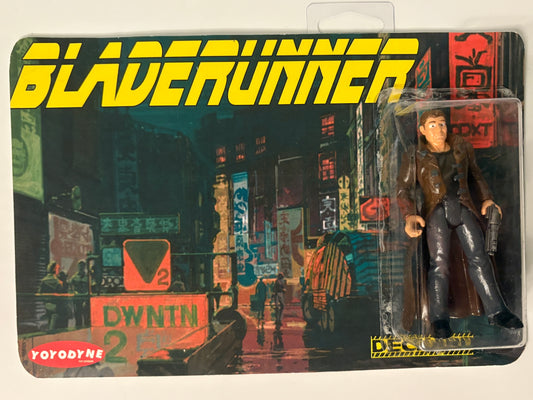 Blade Runner action figure in packaging with cityscape background